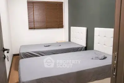 Cozy bedroom with twin beds and modern decor, perfect for a comfortable stay.