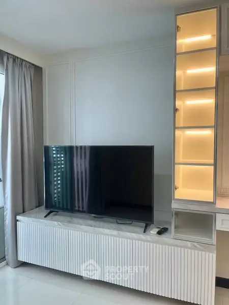 Modern living room with sleek TV unit and illuminated display shelves