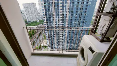 High-rise apartment balcony with washing machine and city view