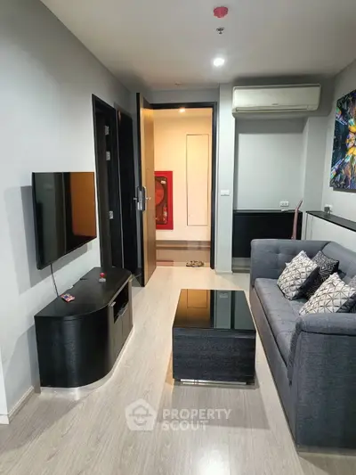 Modern living room with sleek furniture and wall-mounted TV in a stylish apartment.