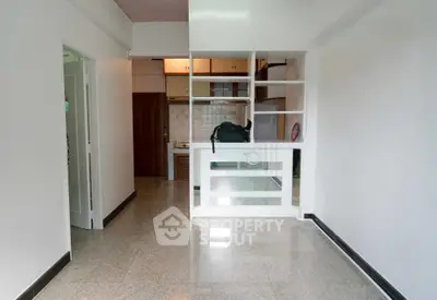 Spacious open-plan living area with tiled flooring and built-in shelving, perfect for modern living.