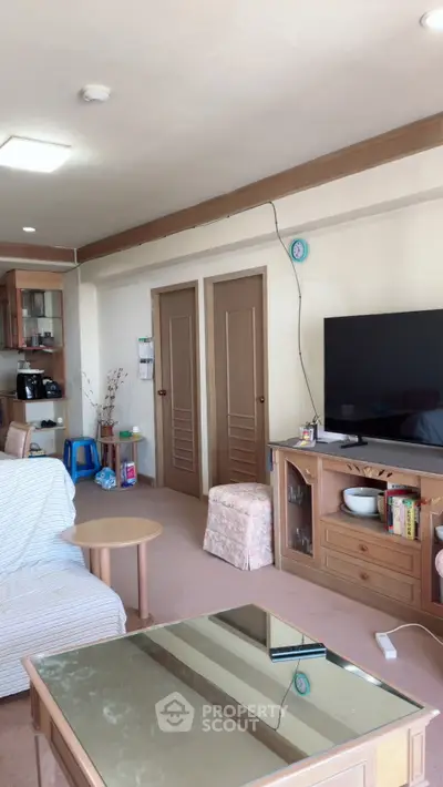 Spacious living room with modern furniture and large TV, perfect for relaxation.