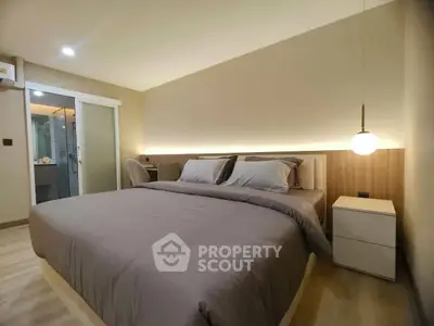 Modern bedroom with cozy lighting and stylish decor in a contemporary apartment.