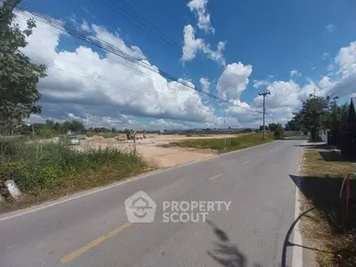Scenic road view with clear skies and open land, perfect for development.