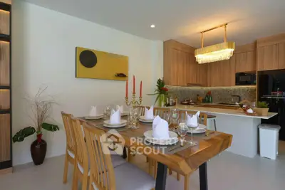 Elegant dining area with wooden table and modern kitchen in open layout
