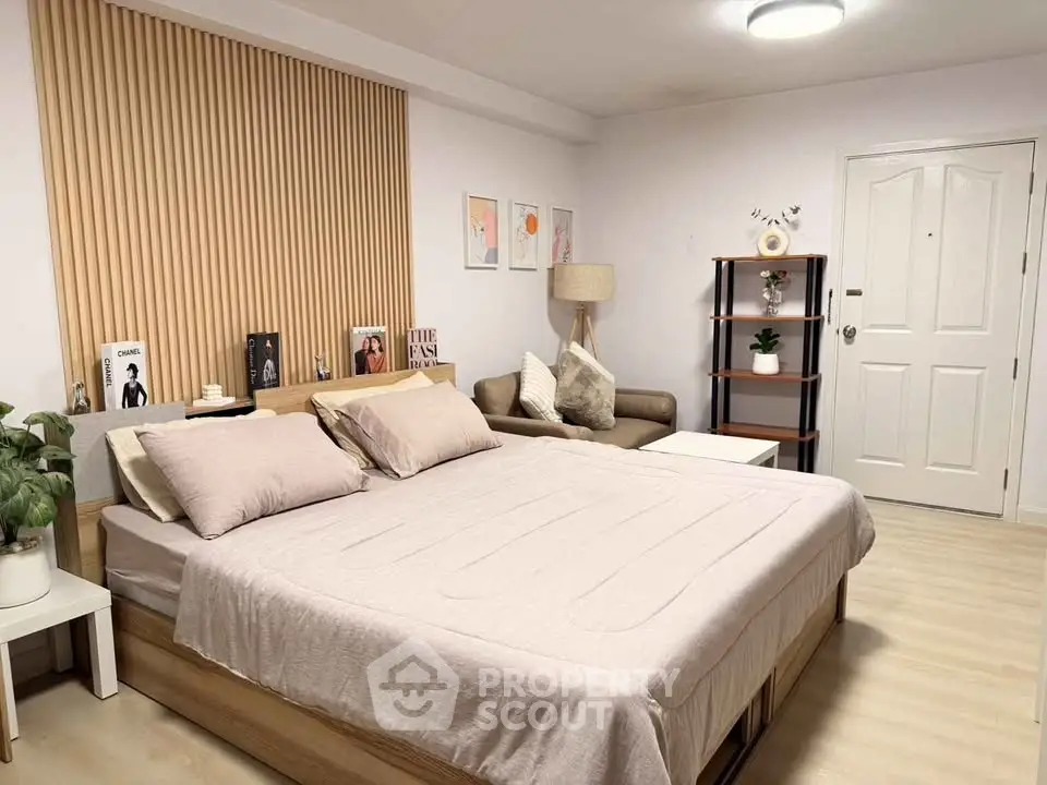 Modern bedroom with stylish decor and cozy seating area, perfect for relaxation and comfort.