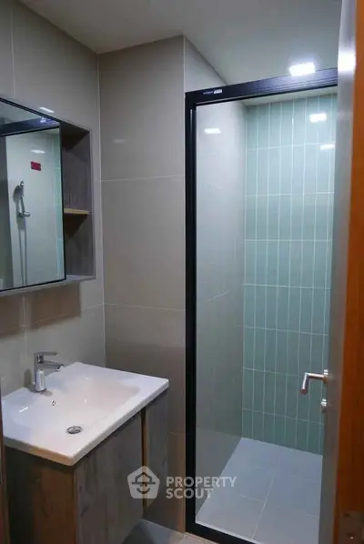 Modern bathroom with sleek shower and stylish vanity in contemporary apartment.