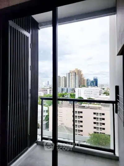 Modern apartment balcony with stunning city view and sleek glass railing.