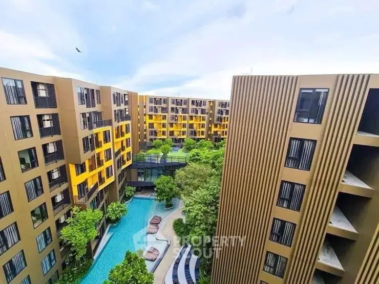 Modern apartment complex with pool and lush greenery, offering a serene urban lifestyle.