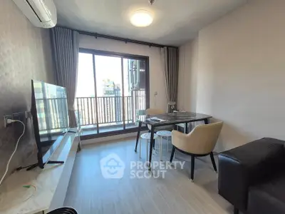 Modern living room with balcony view, featuring sleek furniture and abundant natural light.