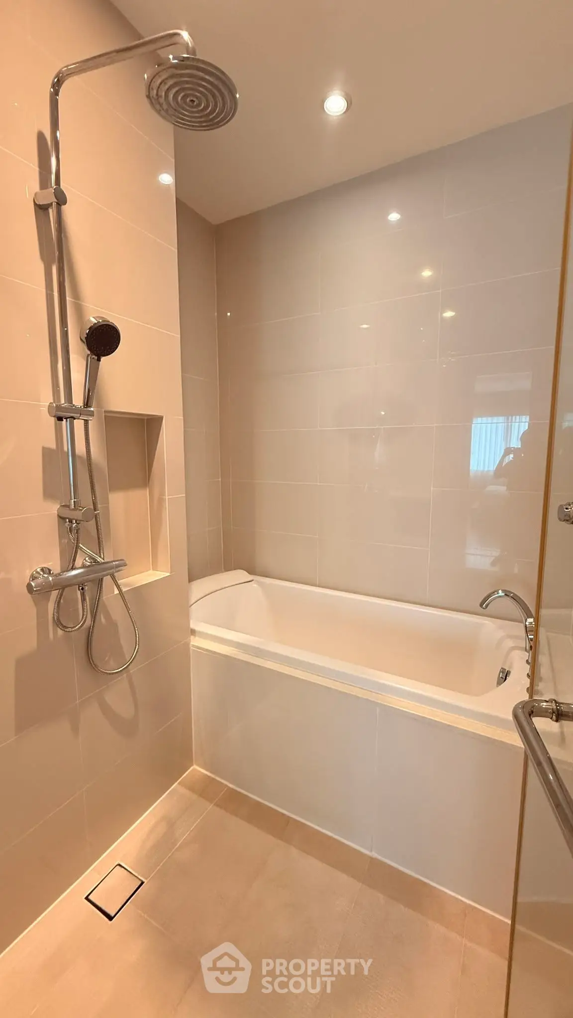 Modern bathroom with sleek shower and bathtub in contemporary apartment.