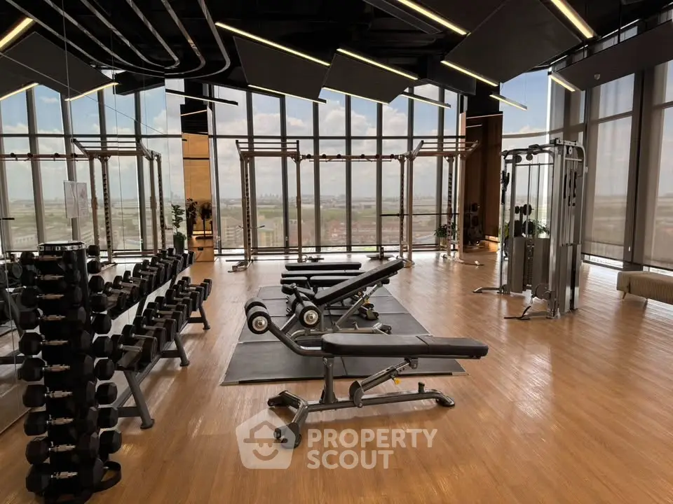 Luxurious high-rise gym with panoramic city views and modern fitness equipment.