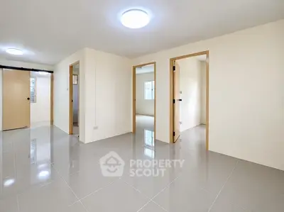 Spacious modern apartment interior with glossy tiled floors and multiple doorways.