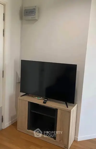 Modern living room corner with sleek TV stand and flat-screen TV, perfect for cozy entertainment setup.