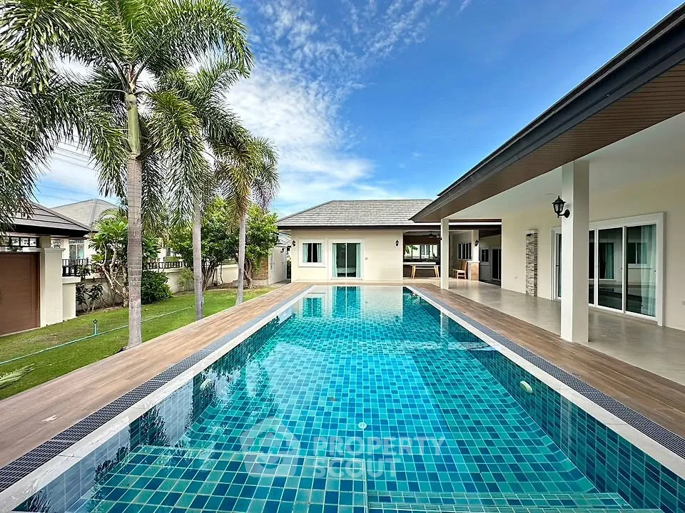 Luxurious villa with stunning pool and palm trees, perfect for tropical living.