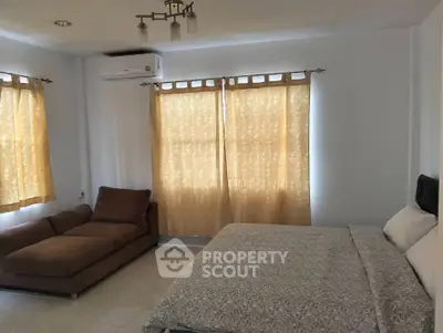 Spacious bedroom with cozy seating and natural light