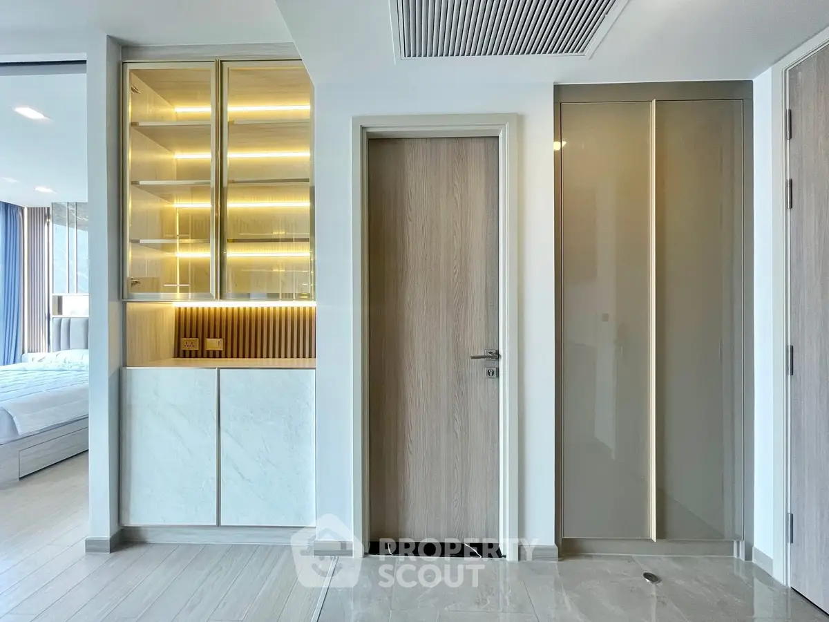 Modern interior with sleek design featuring a bedroom entrance and stylish storage solutions.