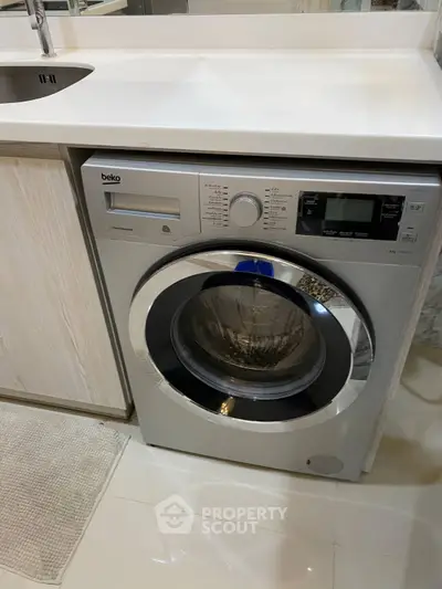 Modern kitchen with built-in washing machine and sleek countertop