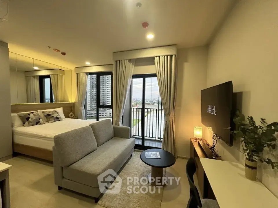 Modern studio apartment with cozy living area and balcony view