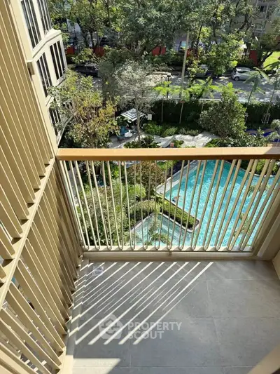 Charming balcony with pool view in modern apartment complex, perfect for relaxation and enjoying the outdoors.