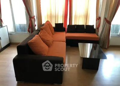 Spacious living room with modern sofa and elegant curtains, perfect for relaxation and entertaining.