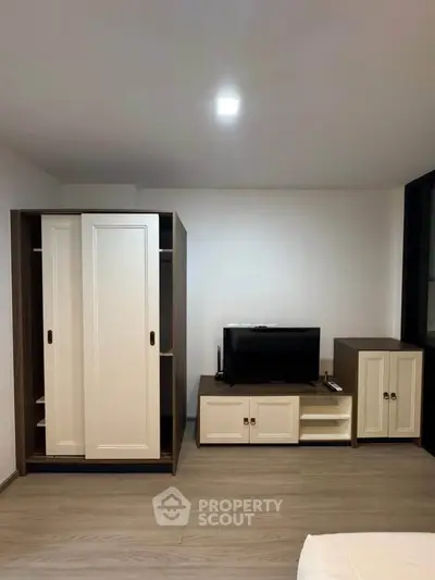 Modern bedroom with sleek wardrobe and entertainment unit, perfect for stylish living.