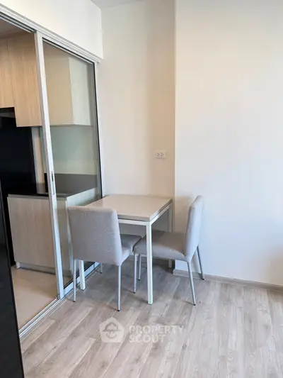Modern compact dining area with sliding glass door and light wood flooring