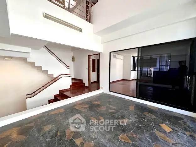 Spacious modern interior with stone flooring and staircase, ideal for stylish living.