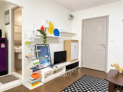Charming living room with modern decor and stylish shelving in a cozy apartment.