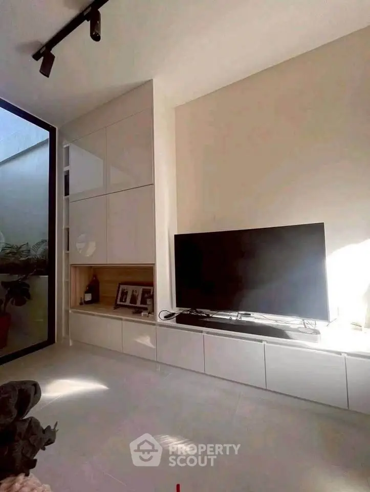 Modern living room with sleek TV setup and natural light