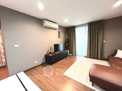 Spacious living room with modern decor and natural light, featuring a sleek air conditioning unit and elegant curtains.