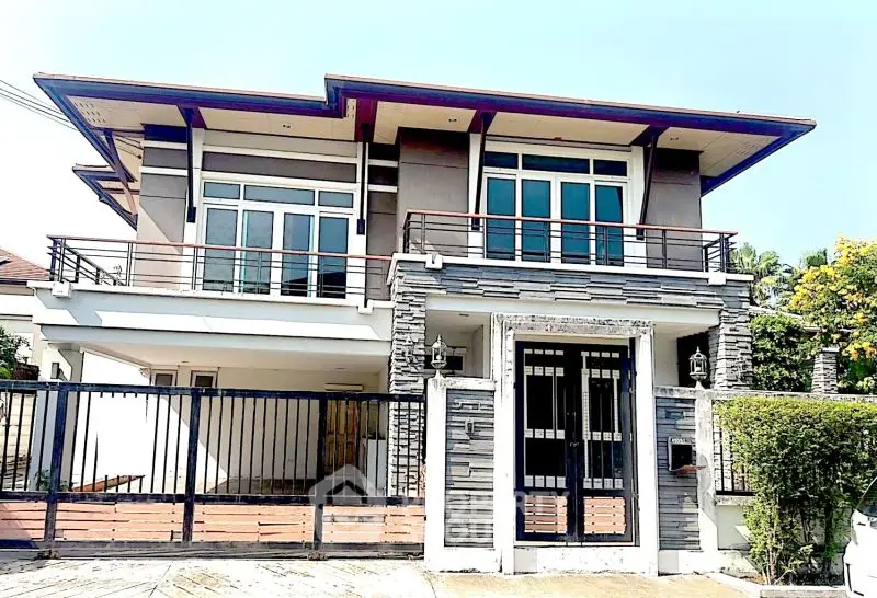 Modern two-story house with sleek design and spacious balcony in a serene neighborhood.