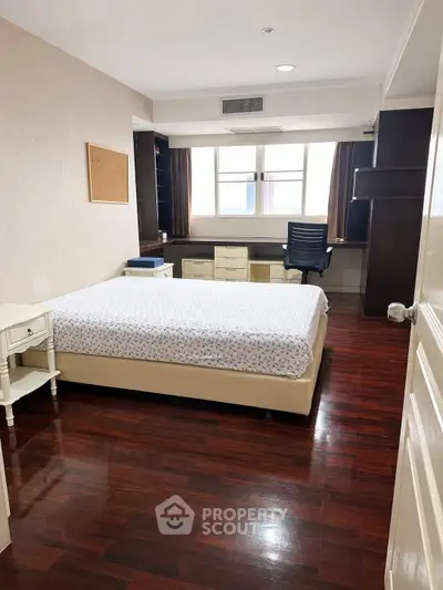 Spacious bedroom with wooden flooring and modern furnishings, ideal for comfort and relaxation.