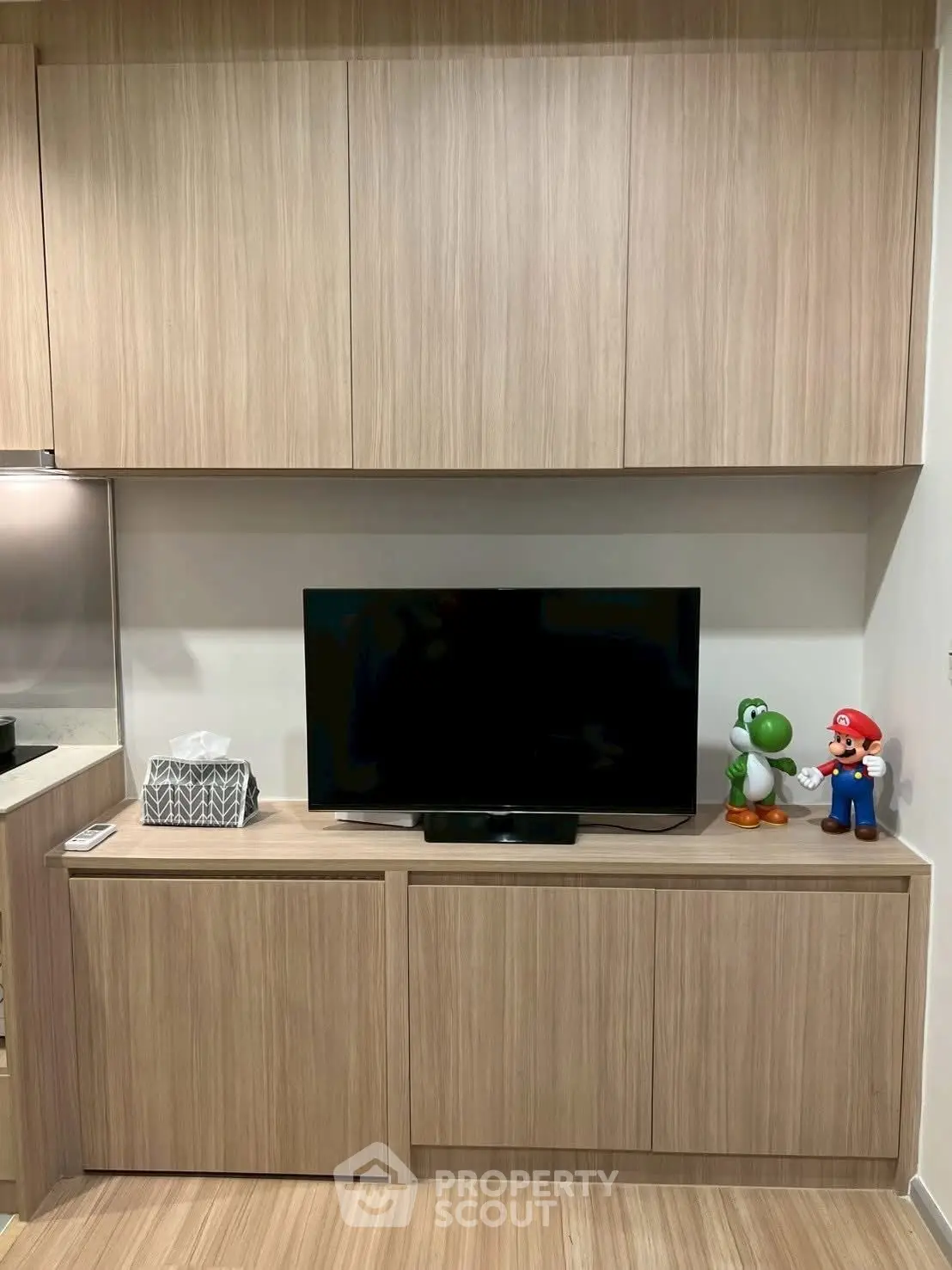 Modern living room with sleek wooden cabinetry and flat-screen TV, perfect for cozy entertainment.