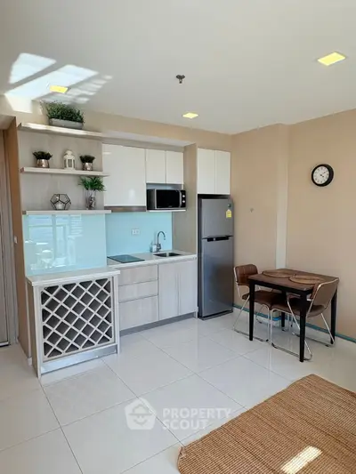 Modern kitchen with sleek cabinetry and dining area in a bright apartment