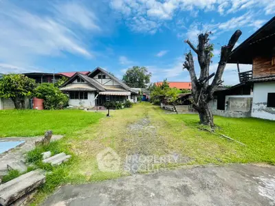 Charming suburban home with spacious green lawn and rustic exterior, perfect for family living.