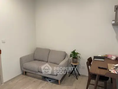Cozy living room with modern sofa and dining table, perfect for small spaces.