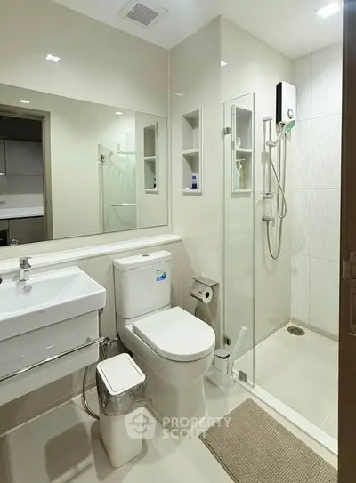Modern bathroom with glass shower and sleek fixtures in a contemporary apartment.