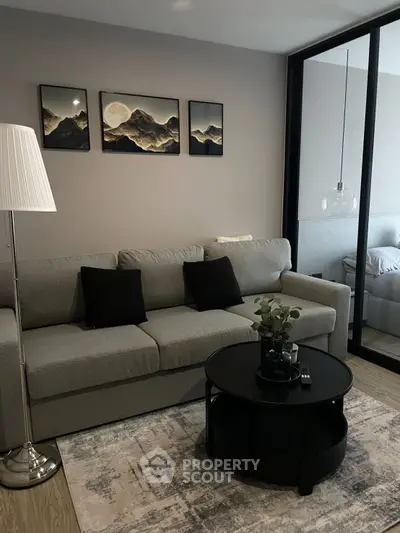 Modern living room with stylish decor and cozy ambiance, featuring a comfortable sofa and elegant artwork.