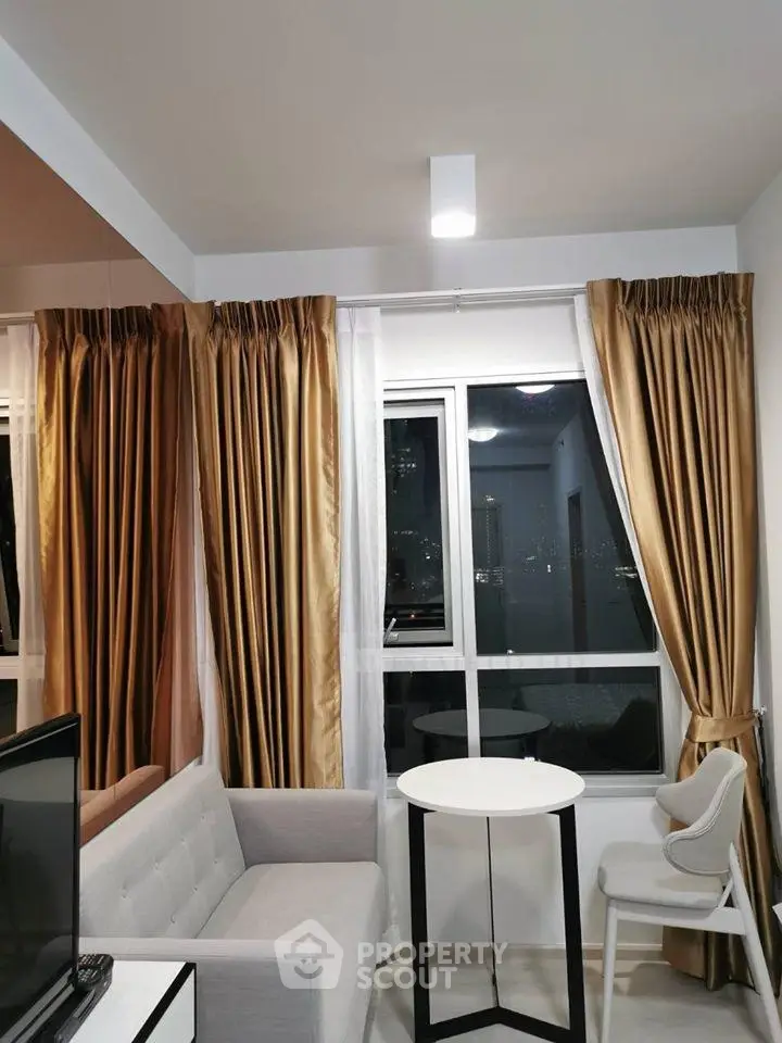 Modern living room with elegant curtains and cozy seating area in a high-rise apartment.
