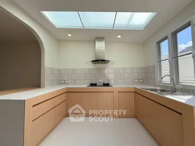 Modern kitchen with skylight and gas stove in a bright, open layout.