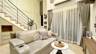 Modern living room with elegant decor and staircase in a stylish apartment