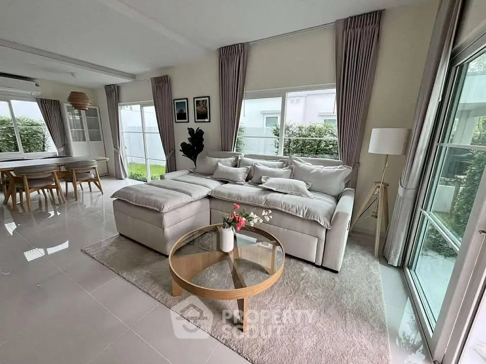 Spacious living room with modern decor and garden view, perfect for family gatherings.