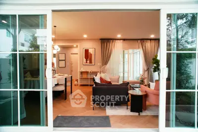 Spacious living room with elegant decor and large sliding glass doors opening to a garden view.