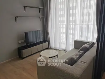 Modern living room with sleek furniture and large windows offering ample natural light.