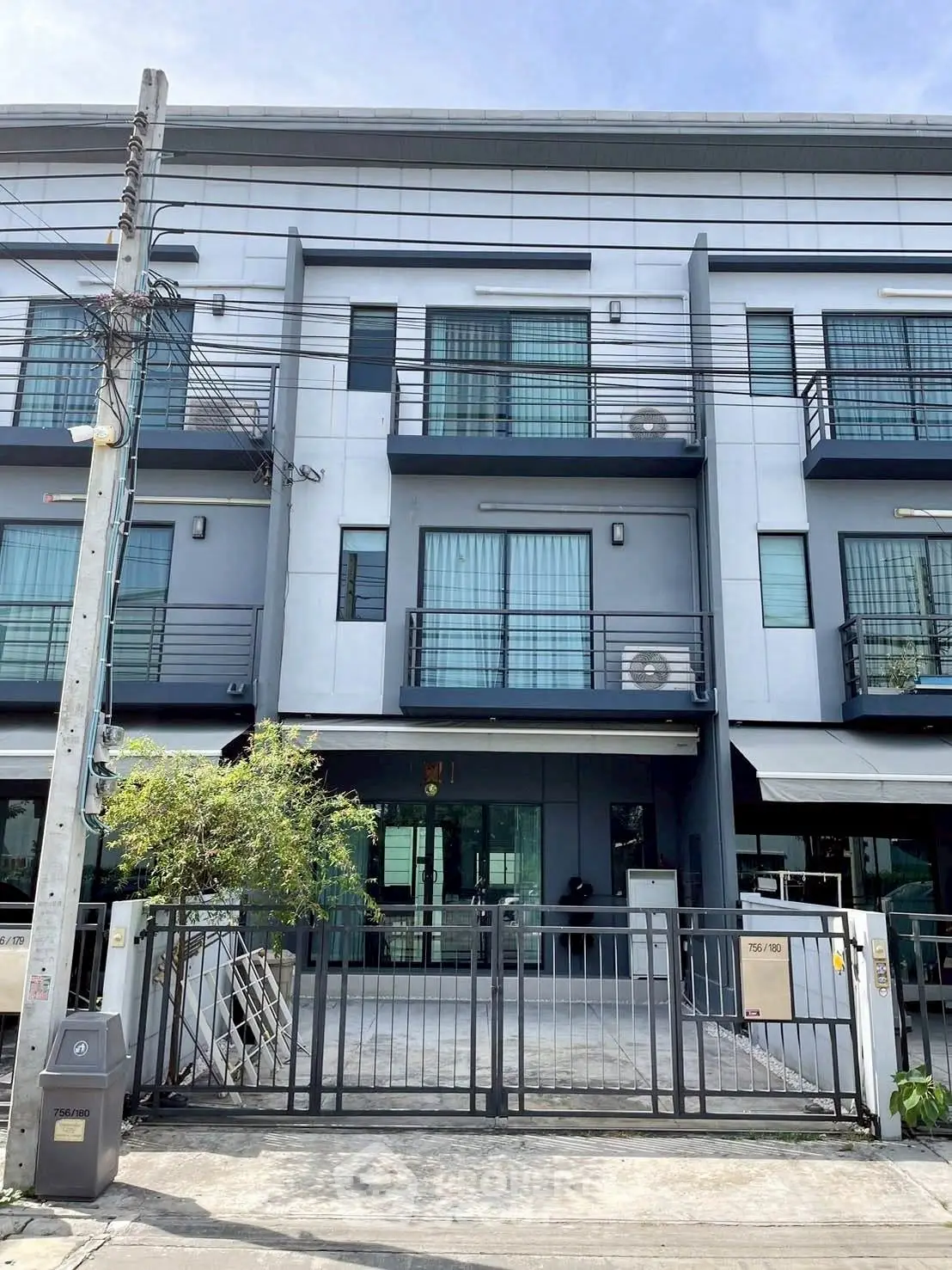Modern townhouse exterior with sleek design and gated entrance