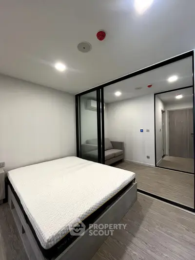 Modern bedroom with mirrored closet and minimalist design, perfect for urban living.