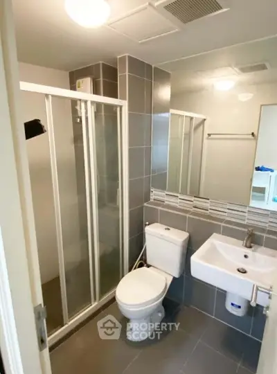 Modern bathroom with sleek shower and contemporary fixtures in stylish apartment.