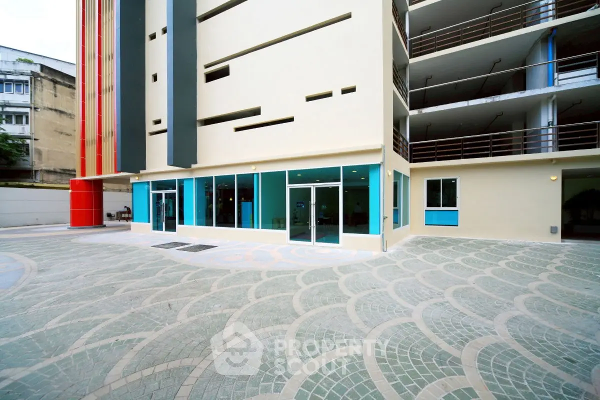 Modern building exterior with unique architectural design and spacious entrance area.