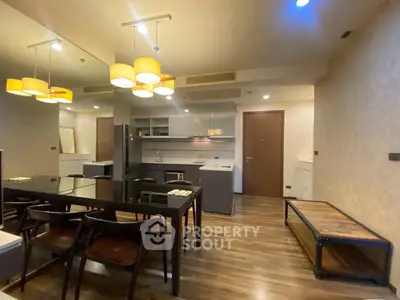 Modern open-layout kitchen and dining area with stylish lighting and wooden flooring